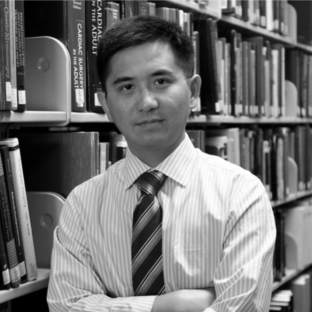 Black-and-white headshot of Jun Huang